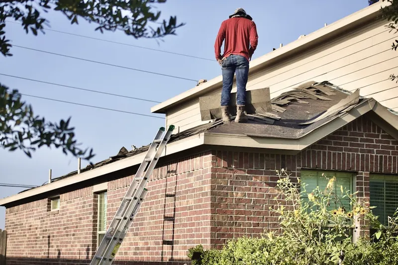 Professional roofer working on a residential roof in Center Lake